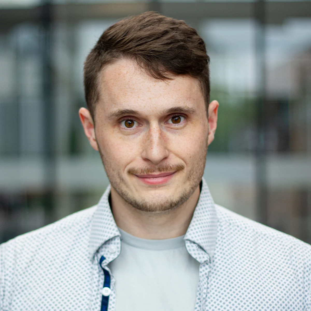 A headshot of David wearing a white collared shirt